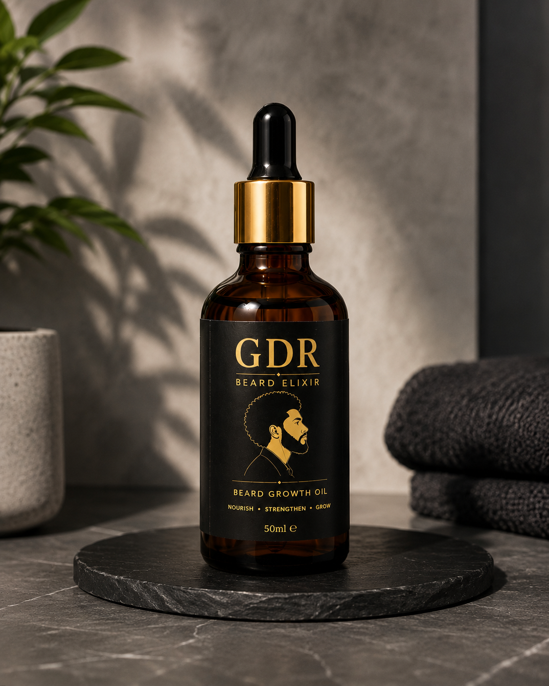 A 50ml bottle of GDR Beard Elixir beard growth oil, featuring an amber glass bottle, black label with gold lettering, and a gold collar with a black dropper cap, set on a dark stone coaster with a gray textured background.