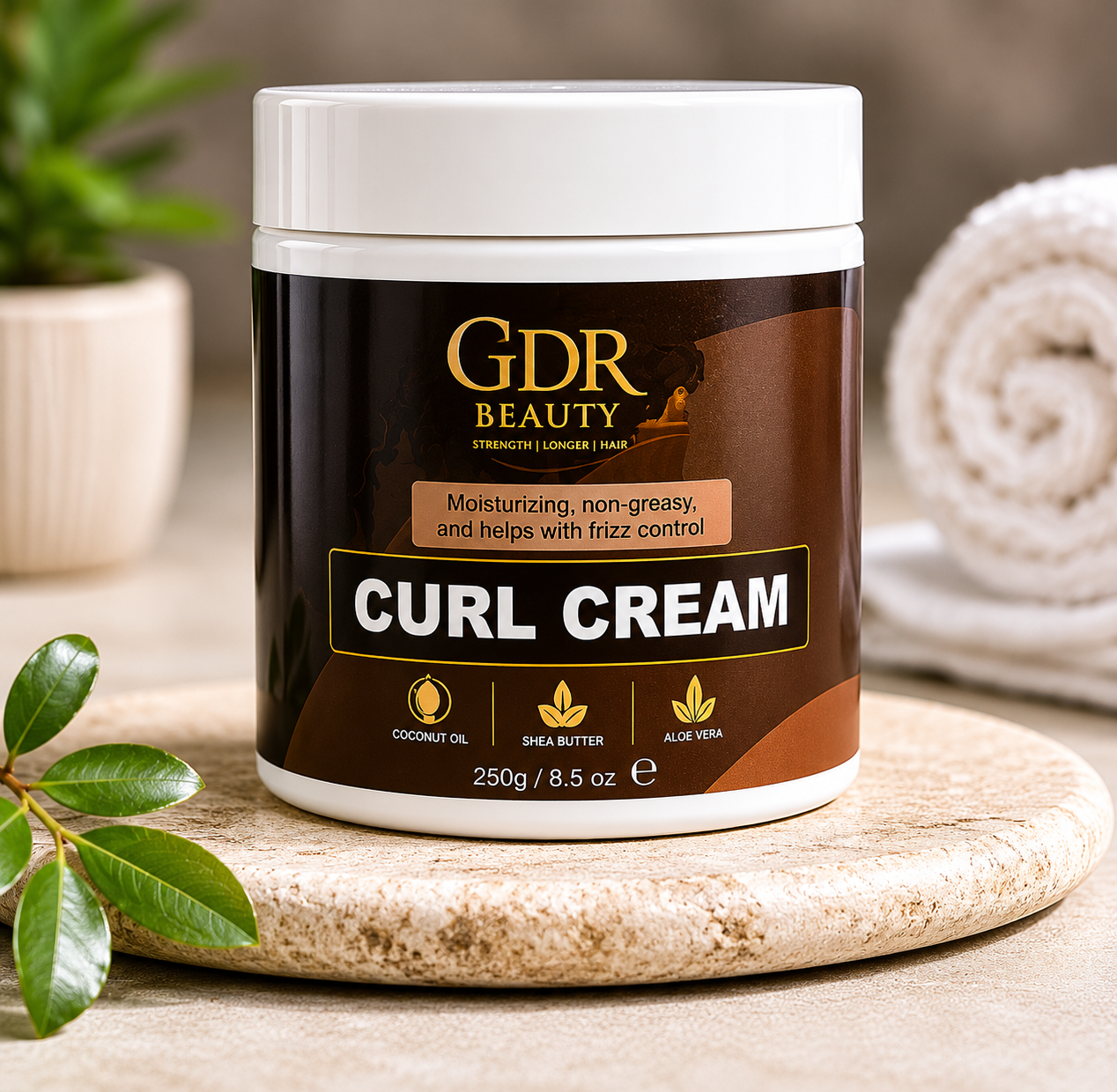A jar of GDR Beauty Curl Cream sits on a round stone coaster, styled with a rolled towel in the background and green leaves in the foreground.