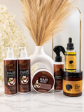 A GDR hair care set arranged on a white marble surface with a white vase of dried grass behind it. The products include two pump bottles of Hair Shampoo and Hair Conditioner, a jar of Hair Mask, a spray bottle of Leave-In Conditioner, and a jar of GDR Growth Booster.